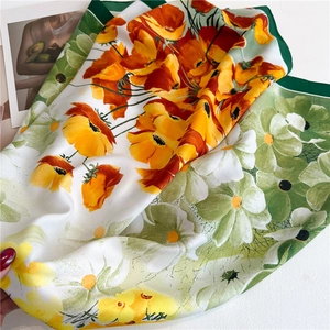 Close-up of vibrant orange poppy and daisy floral patterns on a luxury 90cm silk scarf