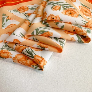 Orange and white floral silk scarf with elegant twill texture for stylish sun protection