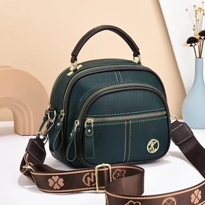 Dark green pebbled leather crossbody bag with gold K logo and stylish wide woven strap