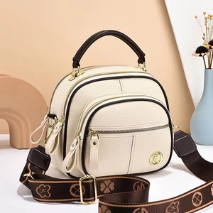 Minimalist beige pebble leather crossbody bag with three zippers and floral woven strap