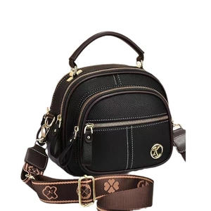 Black pebbled leather crossbody bag with three zipper compartments and a wide brown strap