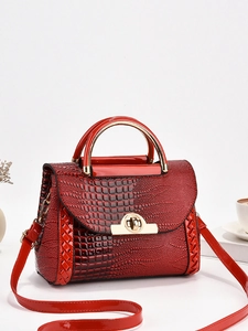 Sac à main rouge à motif crocodile avec fermoir tournant doré sur fond blanc épuré