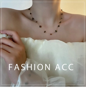 Détail d'un collier doré élégant avec perles de pierre naturelle verte sur un mannequin