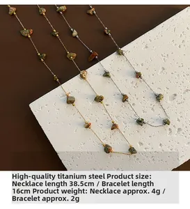 Détail d'ensemble bijoux en acier titane avec pierres naturelles et fines chaînes dorées