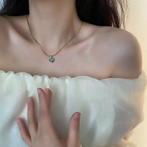 Elegant gold snake chain necklace with iridescent abalone shell heart pendant on model