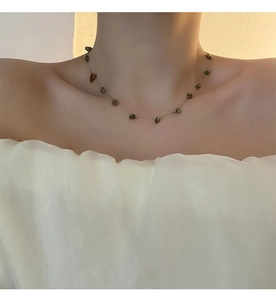 Gros plan détaillé du pendentif en pierre naturelle sur collier en acier titane doré