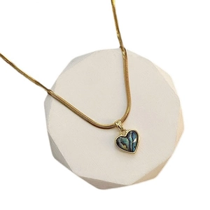 French style gold heart pendant necklace with iridescent abalone shell inlay on white stand