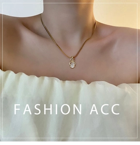 Détail du collier pendentif feuille dorée avec gemme blanche et zircons sur mannequin