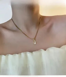 Gros plan d'un collier feuille d'or avec pendentif goutte d'opale sur un mannequin