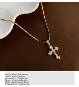 Détail du pendentif croix dorée avec zircons blancs sur une chaîne maille serpent