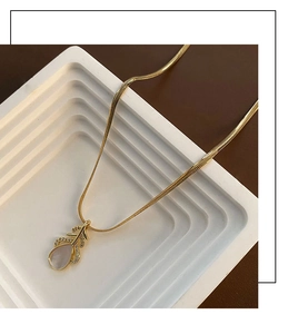 Détail du collier feuille dorée avec incrustation de nacre en poire et zircons brillants