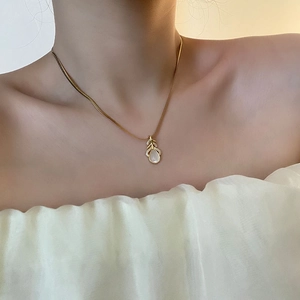 Collier à pendentif feuille dorée avec pierre blanche et cristaux sur chaîne serpent