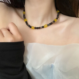 Handcrafted beaded necklace featuring yellow resin stones on a stylish choker worn by model