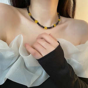 Beaded necklace with yellow stone pendant shown on neck for women in minimalist style