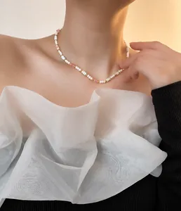 Detail einer Perlenkette mit bunten Edelsteinen am Hals einer eleganten Frau