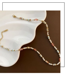 Detailaufnahme der Perlenkette mit rosa und blauen Steinen sowie goldenem Karabinerverschluss