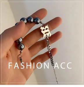 Détail du bracelet en acier titane avec perles bleues et pendentif caractère chinois 'Fu'