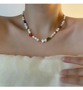 Nahaufnahme der Perlenkette mit bunten Glasblumen an einem Modell für eleganten Look