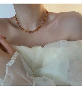 Primo piano della collana di quarzo fragola fatta a mano indossata su maglia a sbuffo