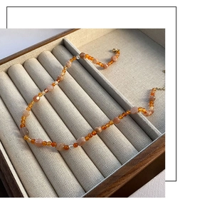 Dettaglio della collana di quarzo fragola con chiusura a moschettone in oro su velluto