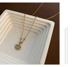 Vue détaillée du collier pendentif cœur doré avec pierre œil-de-chat sur un support blanc