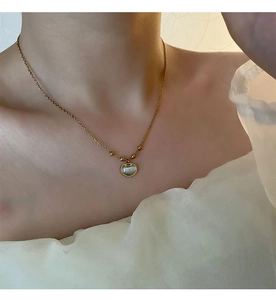 Détail du collier Ruyi en acier titane doré avec pierre œil-de-chat au cou