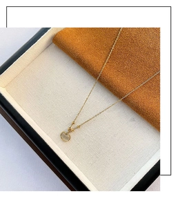 Détail du collier en titane doré avec pendentif cadenas Ruyi et pierre d'opale