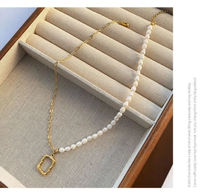 Detail of titanium steel pearl necklace with vintage gold rectangle pendant on velvet box