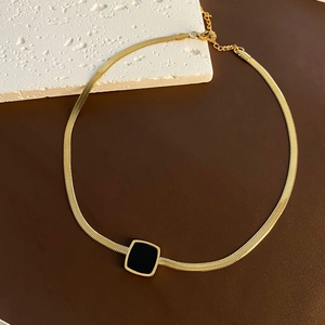 Élégante chaîne serpent dorée avec pendentif carré noir dans un style de luxe minimaliste