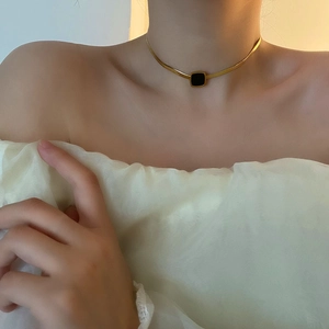 Élégant collier à chaîne serpent dorée avec un pendentif carré noir minimaliste pour femme