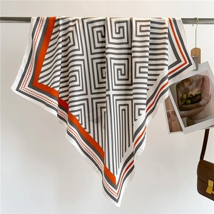 Detail eines 90cm Seidenschals mit geometrischem Muster und orangefarbenem Kontrastrand