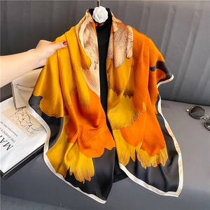 Détail du foulard élégant en satin orange et noir avec une texture brillante