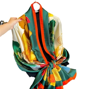 Elegant emerald silk scarf with vibrant yellow ginkgo leaf patterns and orange borders
