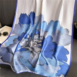 Elegante scialle di seta a fiori blu con accessori di moda su una scrivania