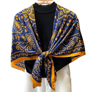 Élégant foulard en soie 110cm avec motifs vintage bleu et orange sur un pull noir