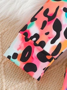 Détail rapproché des poignets de la tenue pour bébés filles avec imprimé léopard coloré