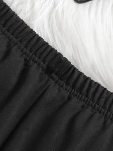 Gros plan sur la taille élastique du pantalon évasé noir pour fille au tissu tricoté
