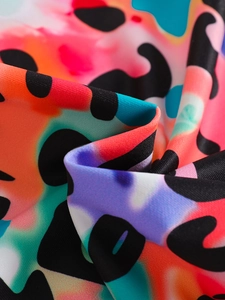 Gros plan sur un tissu tie-dye arc-en-ciel avec des motifs léopard noirs