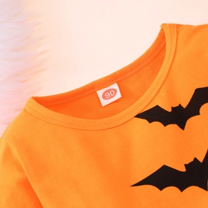 Detail eines orangefarbenen Langarmshirts mit Fledermausprint und Größenetikett 90
