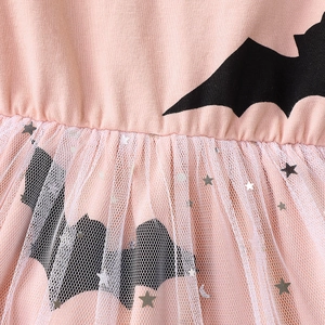 Detail von rosa Strickoberteil mit Fledermaus-Patch und Tüllrock mit Silbersternen