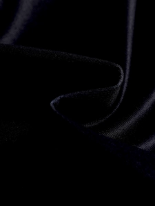 Gros plan sur la texture du satin noir lisse montrant l'aspect brillant et les plis