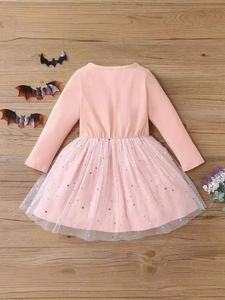 Rosa Halloween-Tüllkleid für Mädchen mit silbernen Sternen auf dunklem Holzhintergrund