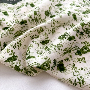 Détail de la texture à chevrons sur tissu blanc avec motifs verts de maisons et d'arbres
