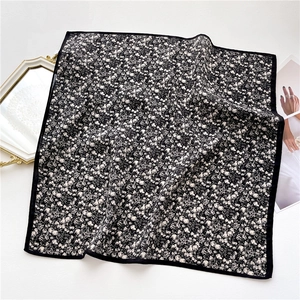 Detailed view of black and white floral square scarf with fine silk-like herringbone texture