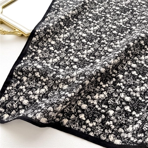 Close-up of vintage black floral scarf with small white flower and fruit patterns