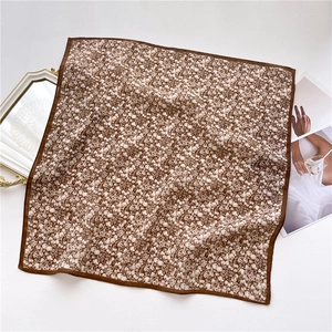Close-up of brown floral square scarf showing soft texture and premium silk-like fabric