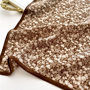 Detail of floral silk scarf with vintage coffee tone and hand-drawn white patterns