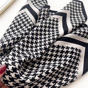 Detailed view of houndstooth pattern and smooth fabric texture on this elegant scarf