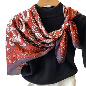 Elegant red paisley print silk-satin scarf styled on a black sweater for women