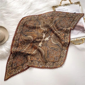 Détail du motif paisley vintage sur foulard en soie plissé avec texture riche